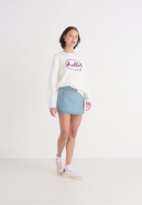Hvit hettegenser med "hello" i dyp rød, paret med en lyseblå denim miniskjørt og rosa høy-topp sneakers. Enkel, uformell antrekk.