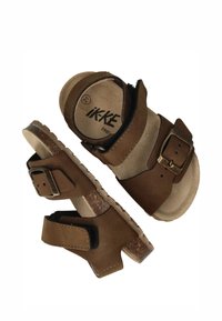 Bruine sandalen met een suede-achtige textuur, voorzien van verstelbare banden, metalen gespen en een kurken voetbed. Ontworpen voor comfort en ondersteuning.