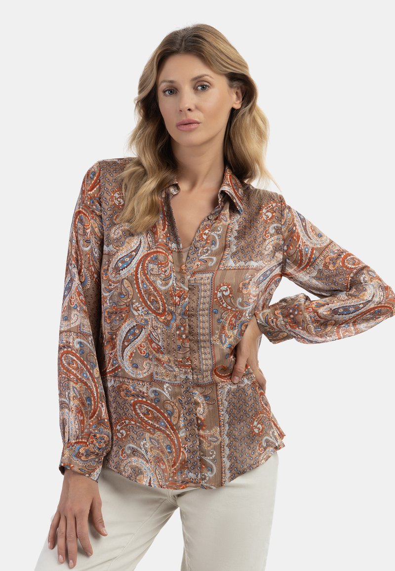 Blusa di seta a maniche lunghe con motivo paisley in toni di arancione, blu e marrone, dotata di chiusura a bottoni e colletto classico.