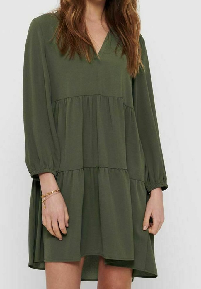 Olivegrünes, locker sitzendes Kleid mit V-Ausschnitt, langen Ballonärmeln und gestuftem Design. Weicher Stoff mit glatter Textur.