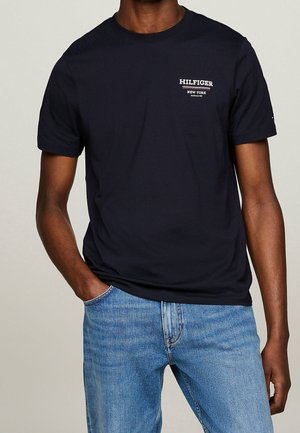 Maglietta di cotone blu navy con maniche corte, caratterizzata dal logo "HILFIGER NEW YORK" in bianco e rosso sul petto. Vestibilità casual, texture liscia.