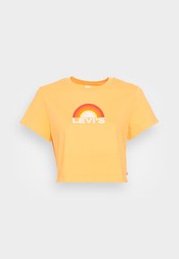 Zastřižené žluté bavlněné tričko s kulatým výstřihem. Obsahuje vícebarevnou grafiku duhy a bílý text "LEVI'S". Krátké rukávy.