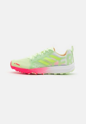 Jasnozielony trailowy but do biegania Adidas Terrex z neonowo różową podeszwą i trzema odblaskowymi paskami po boku.