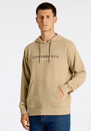 Sudadera con capucha beige y un bolsillo tipo canguro en el frente, con el texto "Copenhague Lindbergh" en gris oscuro. Tejido suave, corte relajado.