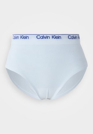 Hvite bomullsører med en blå strikkebånd som har "Calvin Klein"-logoen. Glatt tekstur og klassisk høy midje-design, uten mønstre.