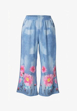 Luźne niebieskie dżinsowe spodnie z elastycznym paskiem w talii i dużymi różowymi kwiatami z zielonymi łodygami nadrukowanymi wzdłuż brzegu.