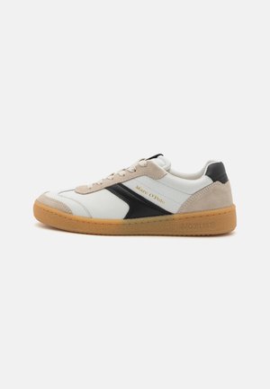 Weiße Leder-Sneaker mit schwarzen und beigen Akzenten, strukturierten Sohlen, abgerundetem Zeh und Schnürung. Mit "Marc O'Polo"-Markenlogo.