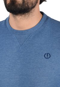 Felpa blu con scollo tondo, collo a costine e un piccolo logo ricamato. Presenta un tessuto testurizzato con un design casual.