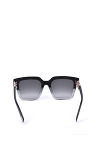 Lunettes de soleil à monture carrée noire avec verres teintés dégradés et branches fines, posées ouvertes sur fond blanc.