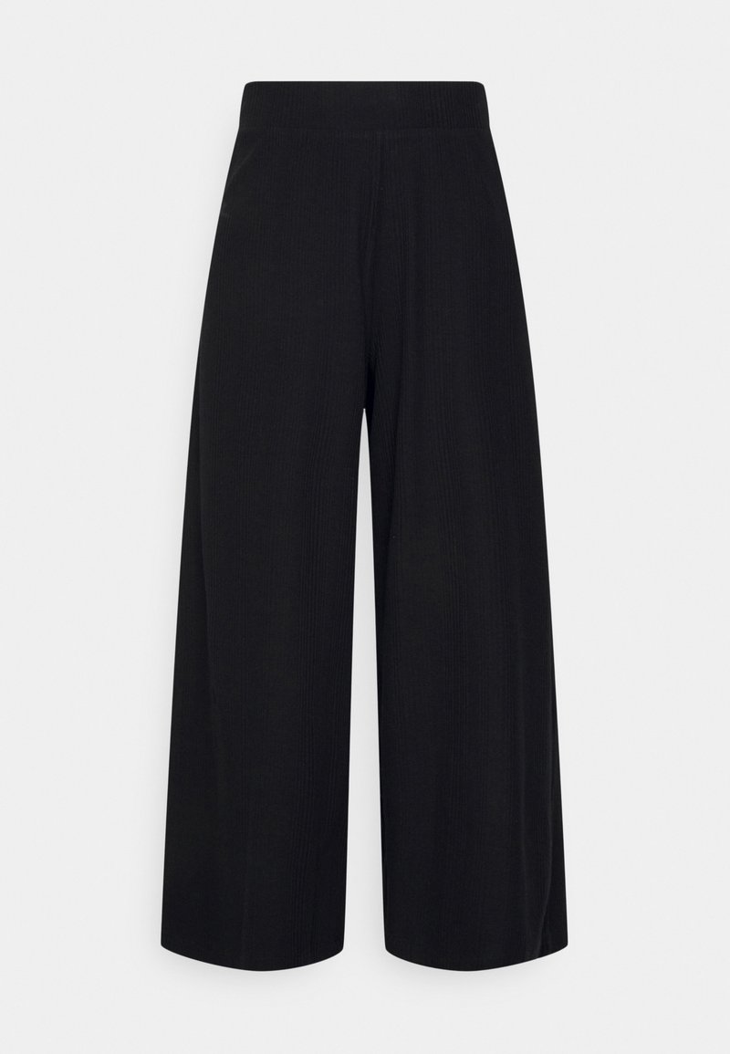 Pantalon noir à coupe large avec une taille haute et un tissu texturé, présenté sur un fond gris clair uni.