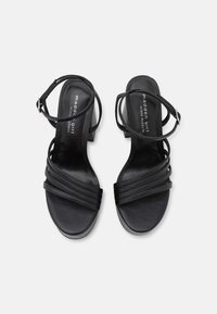 Černé sandály na vysokém podpatku s několika horizontálními pásky, otevřená špička, nastavitelné pásky kolem kotníku s přezkou, hladký povrch a polstrovaná stélka.