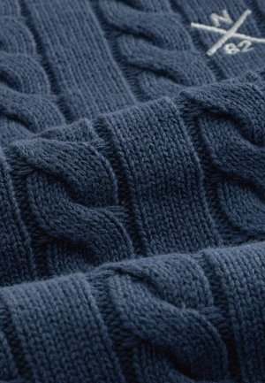 Tamsiai mėlynas megztinis su tekstūruotu pintu raštu ir ribinėmis juostomis. Minkšta, stora siūlė su matomu raštu ir siuvimo detalėmis.