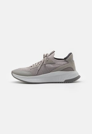 Szary sportowy sneaker sznurowany z fakturowaną, dzianą cholewką, grubą białą podeszwą i logo "BOSS" z boku oraz na podeszwie.
