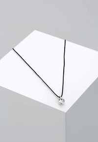 Zwarte koordketting met een ronde zilveren hanger met een heldere, facetteerde edelsteen. De hanger hangt centraal aan het koord.