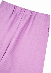 Lichtpaarse, geplooide broek met een elastische tailleband en een label met de tekst "OH APRIL" aan de zijkant. Zachte textuur en vloeiende vorm.