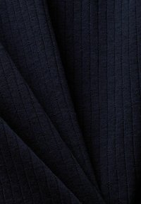 Tummansininen ribbikuvioinen neulottu kangas, jossa on pystysuorat tekstuuriluonteiset viivat ja hienovaraiset viistoiset taitteet.