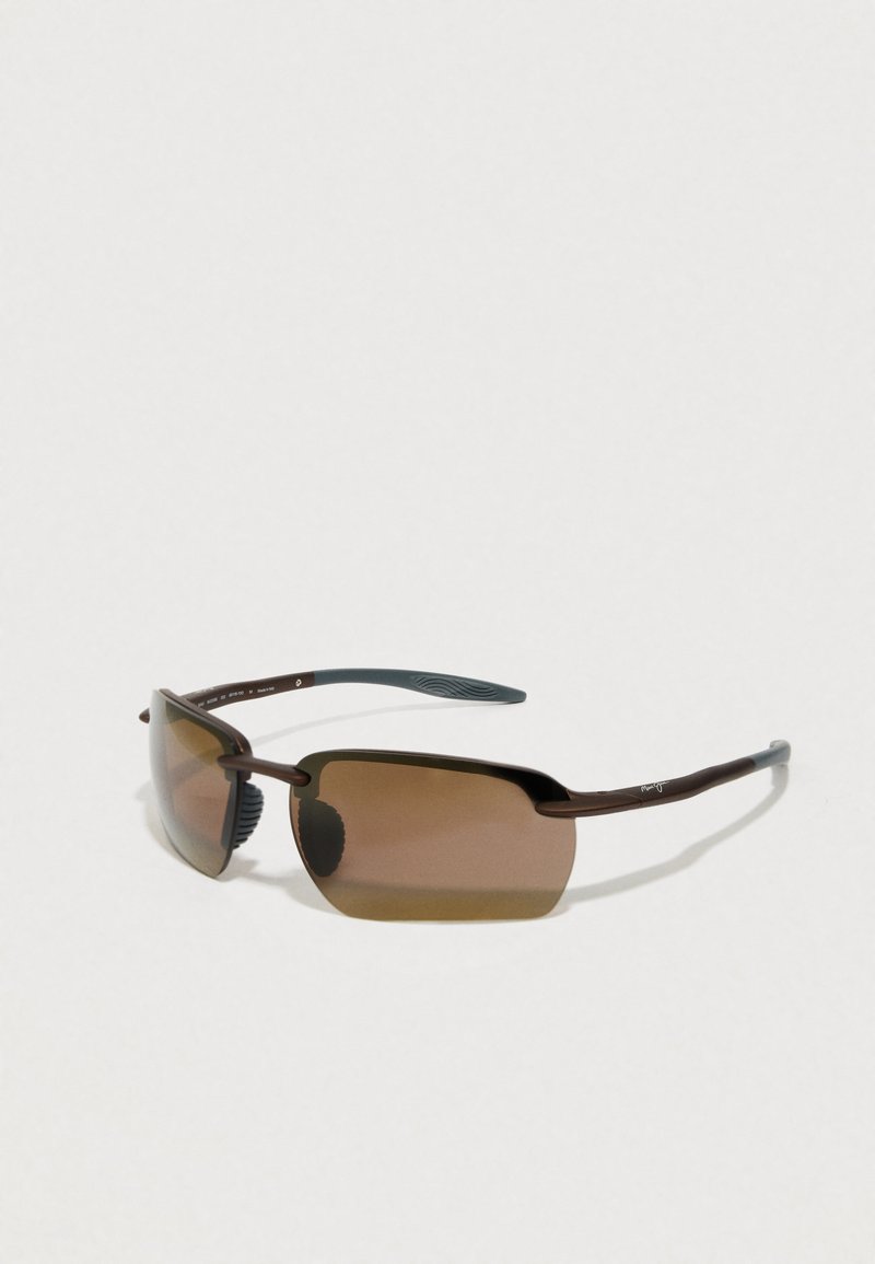 Brown rimless sunglasses with rectangular tinted lenses and curved dark brown temples on a plain light background.