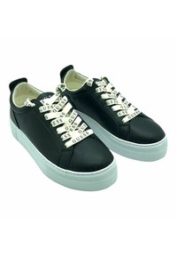 Sneaker nere in pelle con spesse suole bianche in gomma, lacci elastici con il logo "GUESS" e design a metà caviglia.