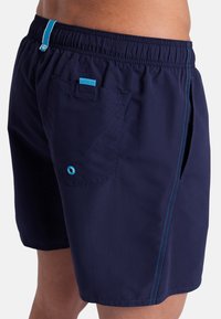 Pantaloni da bagno blu navy con vita elastica, cuciture di contrasto blu, una tasca posteriore con bottone e tasche laterali per comodità.