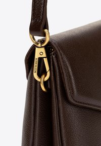 Hnědá kožená kabelka s texturovaným povrchem, vybavená zlatými kovovými doplňky a odnímatelným popruhem, která se vyznačuje elegantním designem a strukturovaným tvarem.