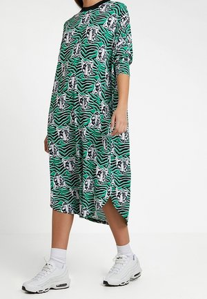 Green dress with black accents, featuring a tiger and zebra stripe pattern. Mid-calf length, loose fit, and side slits for mobility.