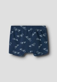 Marineblå shorts laget av mykt materiale, med et gjentatt mønster av lyseblå sikkerhetsnåler og en elastisk midjebånd for komfort.