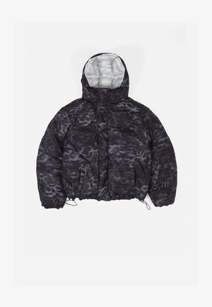 Casaco tipo puffeiro em preto com padrão de camuflagem cinza. Apresenta colarinho alto, fecho de correr à frente e bainha inferior elástica com cordões.