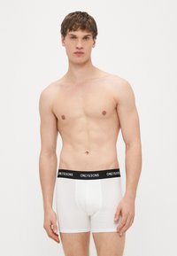 Valkoiset puuvillaiset bokserishortsit, joissa musta elastinen vyötärönauha, jossa on "ONLY & SONS" -logo. Sileä pinta, istuva malli.