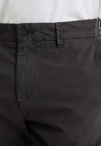 Ciemnoszare bawełniane spodnie o gładkiej fakturze, z przednią kieszenią i pojedynczym guzikiem zapinającym w talii.