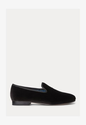 Scarpa slip-on in velluto nero con tacco basso, caratterizzata da un bordo testurizzato blu attorno all'apertura. Superficie liscia, design a punta arrotondata.