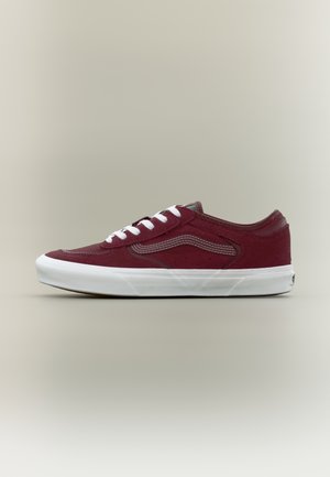 Low-top maroon suede sneaker with white laces, white rubber sole, and wavy side stitching on a plain neutral background.