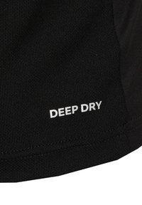Schwarzer Stoff mit strukturierter Oberfläche, auf dem unten der Text "DEEP DRY" in Weiß zu sehen ist, was auf feuchtigkeitsableitende Eigenschaften hinweist.
