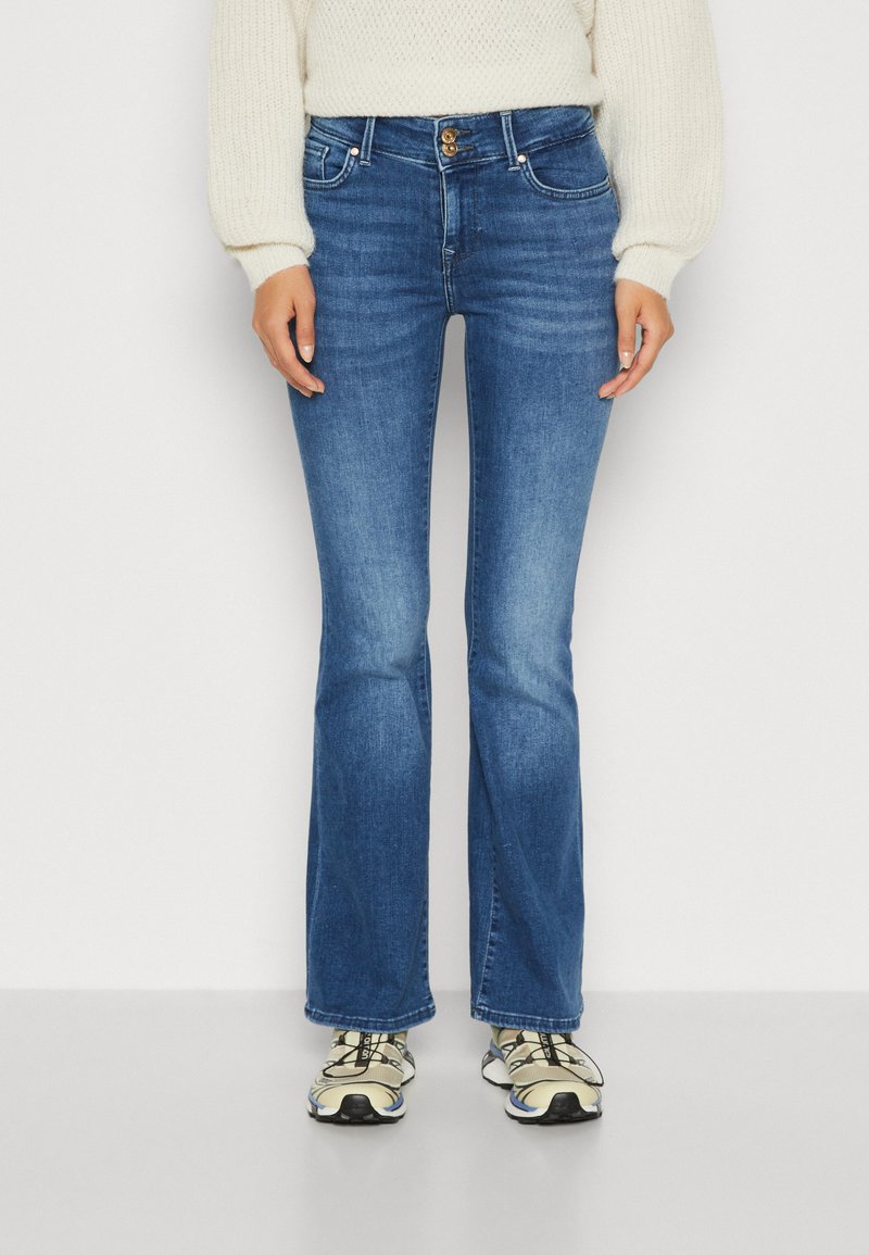 Flared blå denim jeans med en middel vask, der har en knap- og lynlåslukning, fem lommer og diskret falmet på lårene.