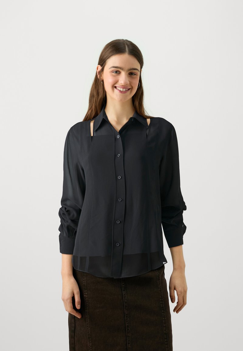 Black, button-up shirt made of lightweight fabric, featuring long sleeves, cut-out accents, and a semi-sheer hem.