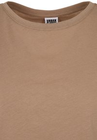 Béžové tričko s okrúhlym výstrihom, so viditeľnými švami okolo výstrihu a vnútornou štítkom s nápisom Urban Classics.