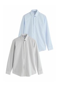 Deux chemises à manches longues à boutons, l'une bleu clair derrière une grise claire, toutes deux avec des cols boutonnés et des boutons blancs.
