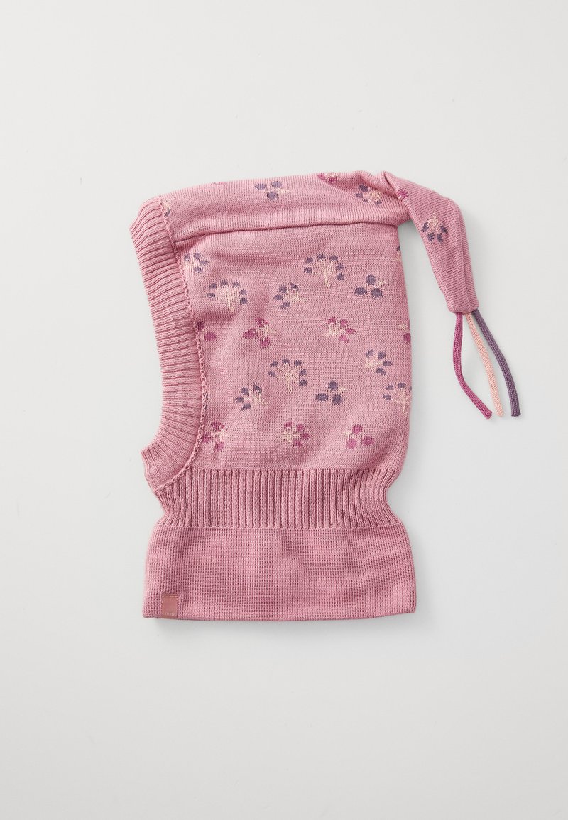 Balaclava rosa lavorata a maglia con bordi a coste, piccoli motivi floreali e una coda annodata con tre pompon di colori diversi su uno sfondo bianco.