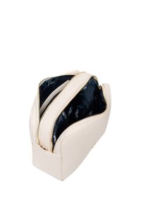 Borsa cosmetica color crema in pelle texturizzata, con due cerniere dorate e una fodera interna scura con motivo.