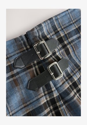 Tela de cuadros azul y marrón con textura suave, con dos correas de cuero negro con hebillas plateadas para el cierre. Cierres visibles.