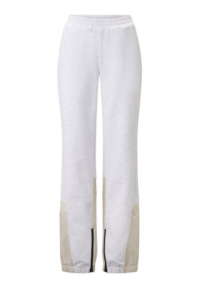 Witte sweatpants met een zachte textuur, voorzien van beige accenten aan de onderzijde en elastische boorden bij de enkels.