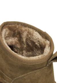 Pruun nubukist saabas, millel on pehme, nugise beež vooder, lai avaus ja õmblusdetail serva ääres. Avatud sisepind on luksuslikult pehme.