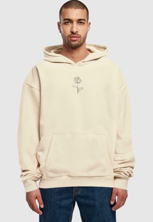 Beige hoodie lavet af blødt materiale, med en frontlomme og en grafisk kontur af en rose i midten. Casual pasform, lange ærmer.