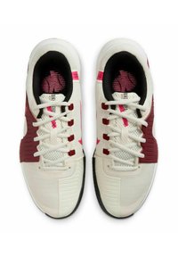Scarpe sportive bianche con tomaia testurizzata, accenti bordeaux, branding rosa e suola in gomma nera; dotate di un tradizionale sistema di allacciatura.