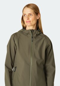 Una chaqueta impermeable de color verde oliva con capucha, cierre de cremallera y bolsillos laterales. Presenta una textura suave y un cordón ajustable en la capucha.