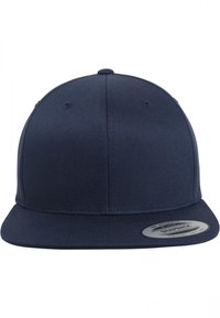 Sötétkék snapback sapka, amely texturált anyagból készült, lapos széle van, kerek teteje és szellőzőlyukak találhatóak az oldalán.