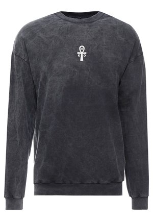 Langarm crewneck sweater in houtskoolgrijs met een klein wit ankh-symbool en de letters A, K, O in het midden van de borst.