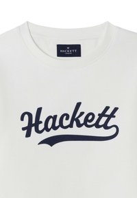 Sudadera blanca con cuello redondo que presenta un logo "Hackett" en cursiva de color azul oscuro en el frente. Material de algodón suave.