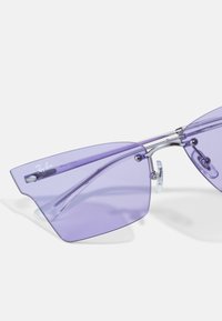 Occhiali da sole geometrici viola con montatura trasparente, dotati di dettagli in metallo argentato e naselli regolabili per comfort e vestibilità.