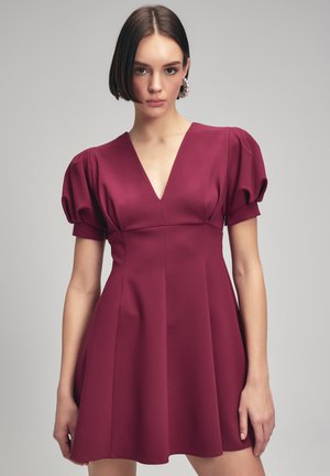 Bordeauxfarbenes Kleid mit tiefem V-Ausschnitt, kurzen Puffärmeln und einem ausgestellten Rock. Hergestellt aus glattem Stoff mit vertikalen Nahtdetails.
