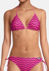 Ensemble de bikini rose comprenant un haut triangulaire et des liens ajustables sur les côtés du bas, avec un motif en zigzag de rose plus foncé.